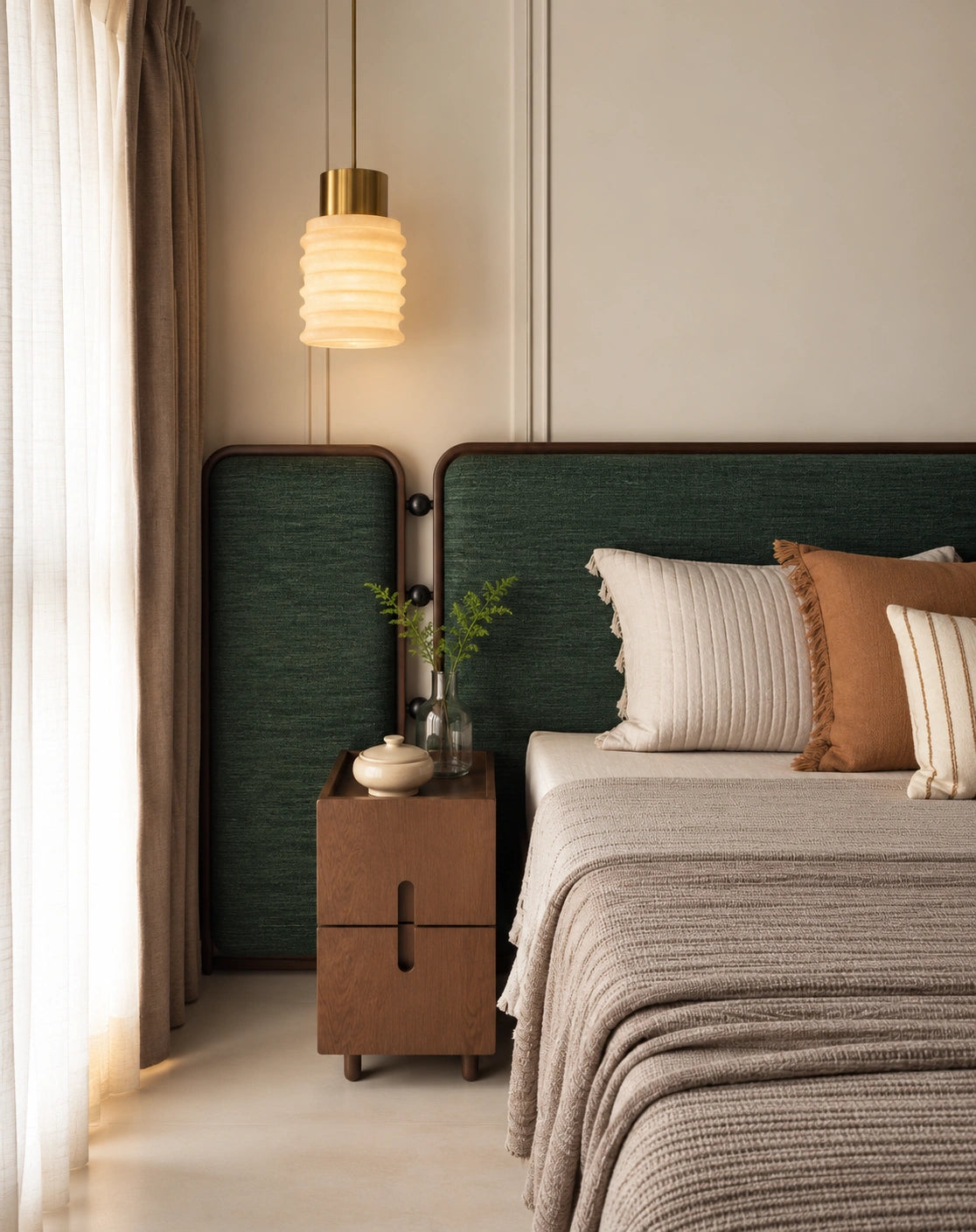 A modern bedroom scene featuring a bed with textured beige bedding, a dark green upholstered headboard, a matching side panel, a wooden nightstand, and a glowing ribbed pendant light.