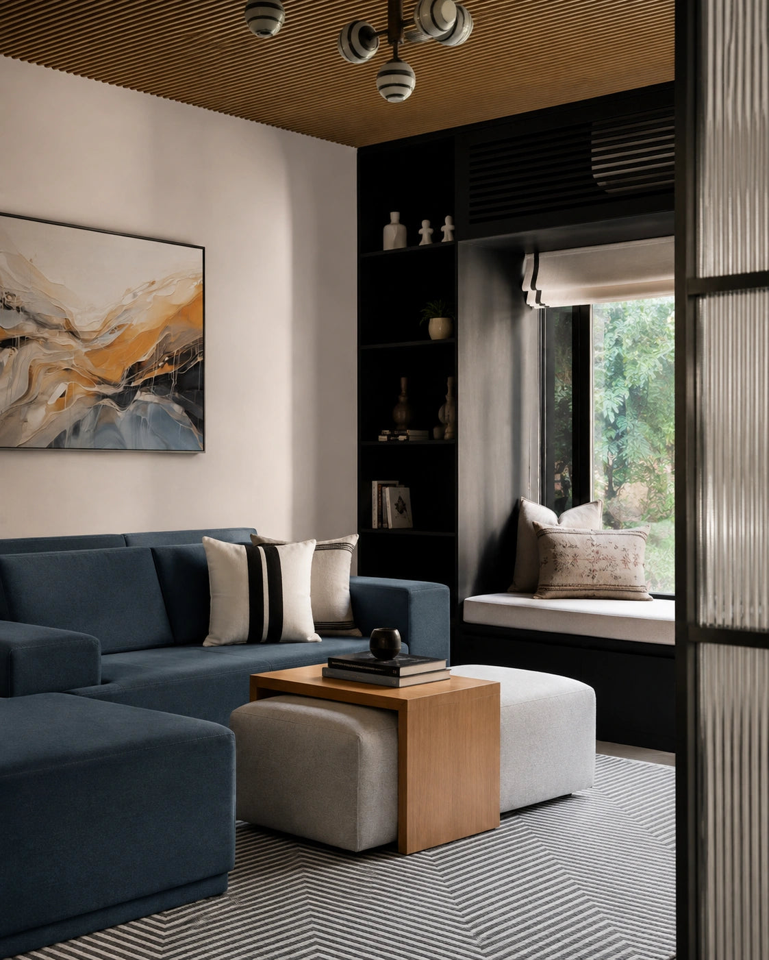 Contemporary living room with a deep blue sofa, neutral accent pillows, light upholstered ottomans, a warm wood side table, built-in black shelving, abstract wall art, a cozy window seat, and a striped geometric area rug beneath a wood slat ceiling.