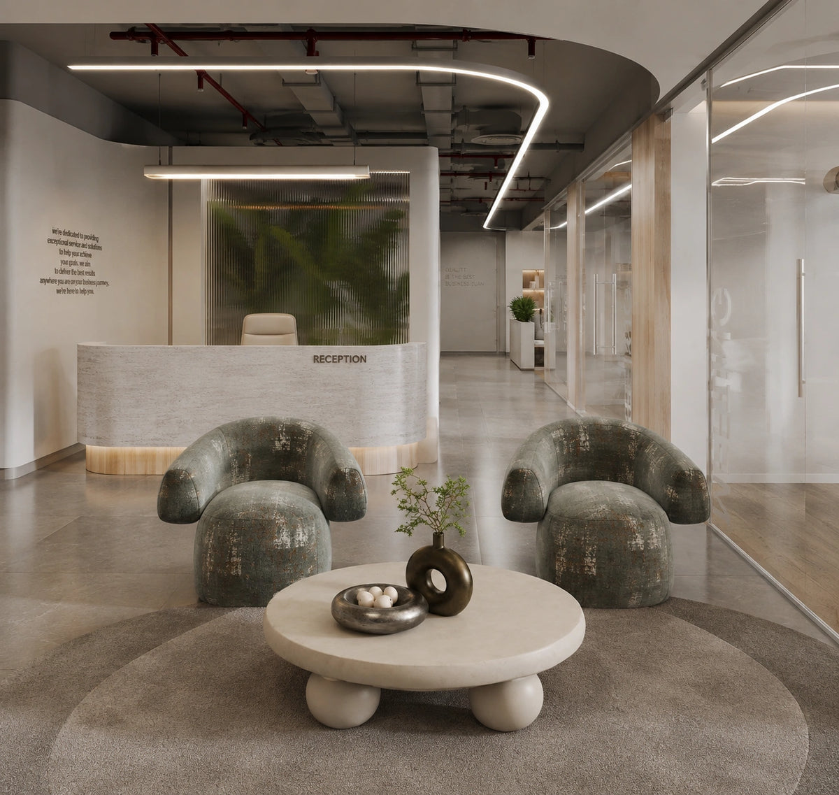 A modern reception lobby interior with two distressed green velvet armchairs arranged around a round beige coffee table on a large gray rug. A curved reception desk, glass-walled offices, and industrial ceiling details are visible in the background.