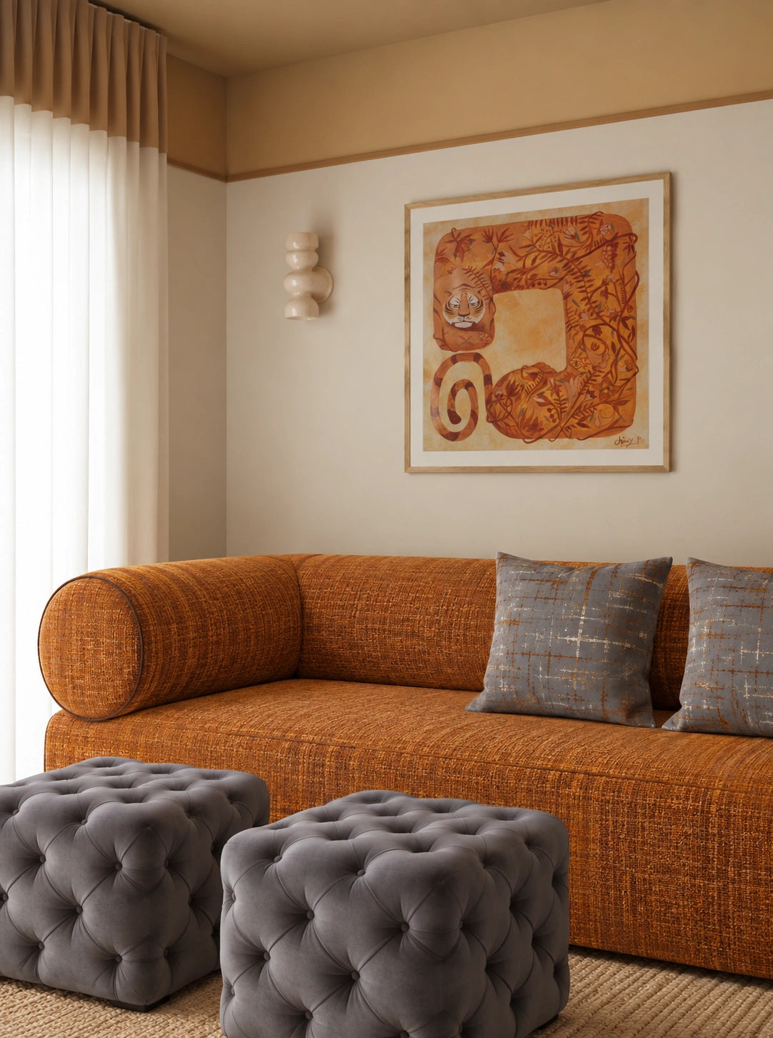 Warm contemporary living room with a textured burnt orange sofa, gray tufted ottomans, blue and gold accent pillows, framed tiger artwork, sculptural wall decor, and soft beige curtains.
